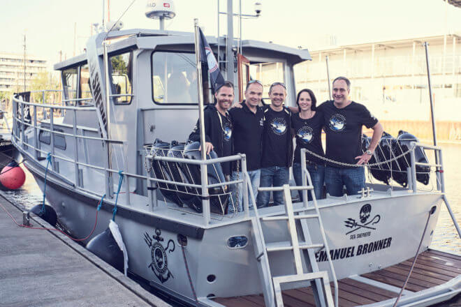 Crew aboard a boat at a dock.